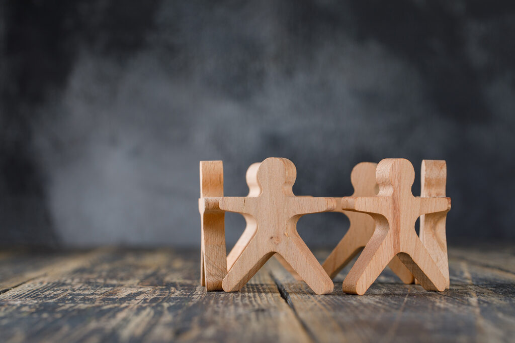 Business success and teamwork concept with wooden figures of peo
