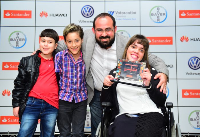As crianças da AACD Nathan Duarte, Samuel Oliveira, Isabella Stoque entregam o troféu para José Batista de Queiroz Filho, CEO e Co-fundador do Canal do Ensino