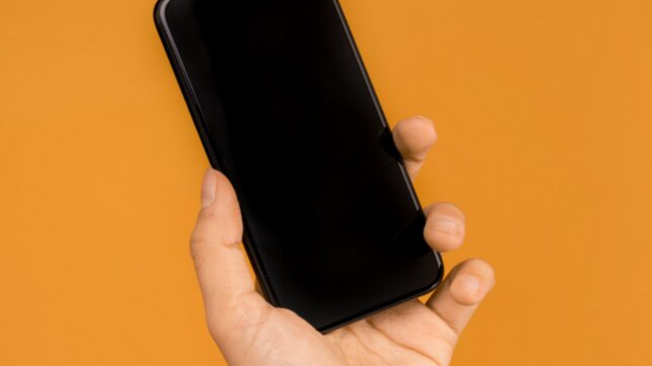 Kwai app on smartphone screen on orange background. Social media